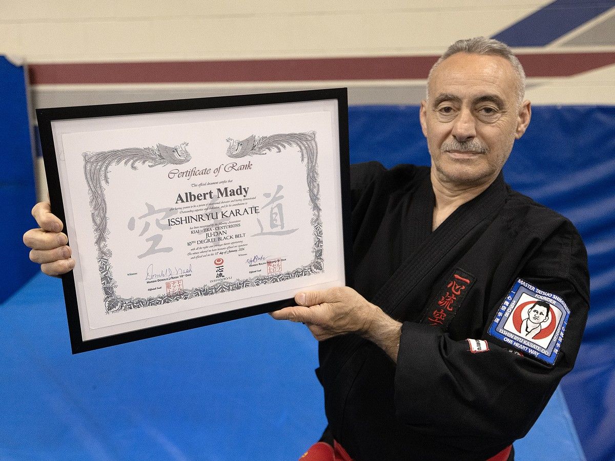 Albert Mady holding his tenth-degree Isshinryu karate black belt certificate
